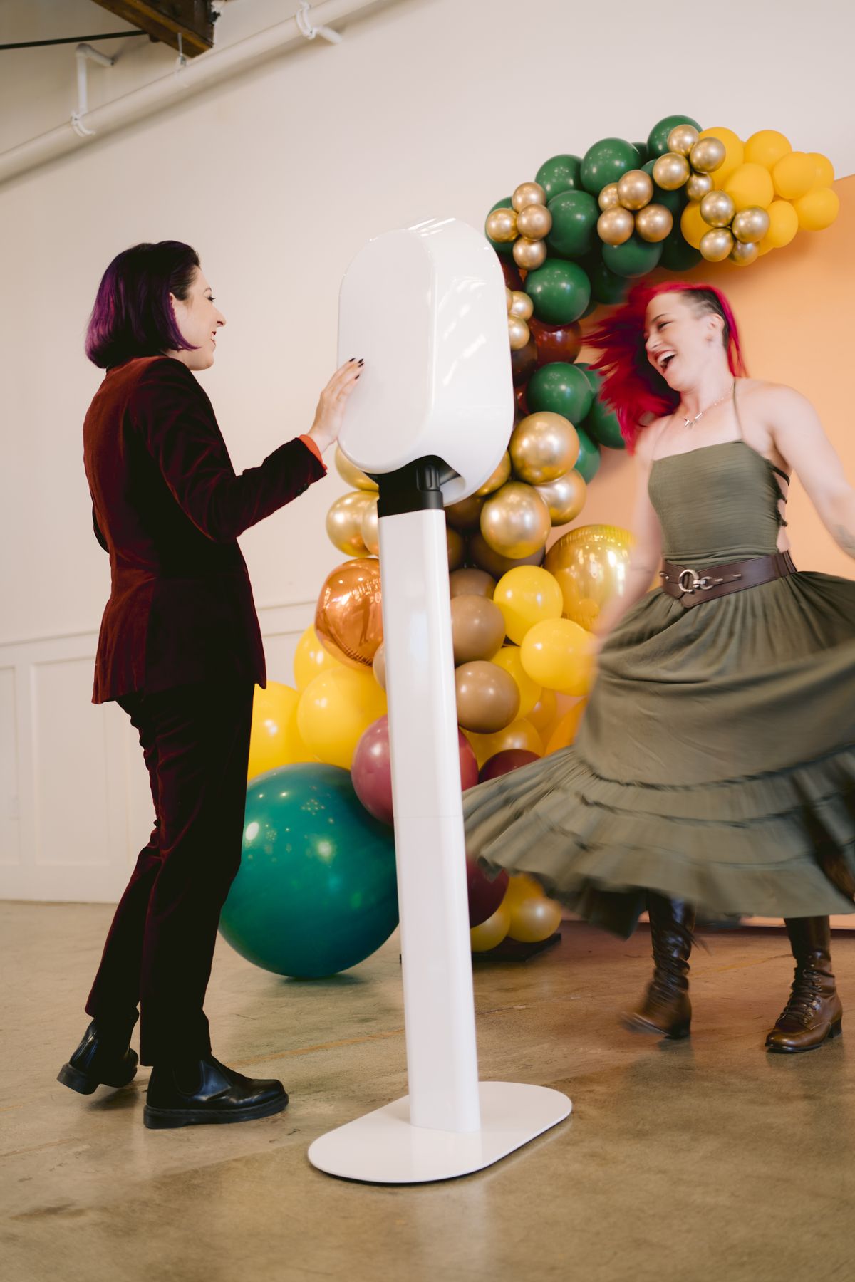 Guests dancing and laughing beside the photo booth at a party
