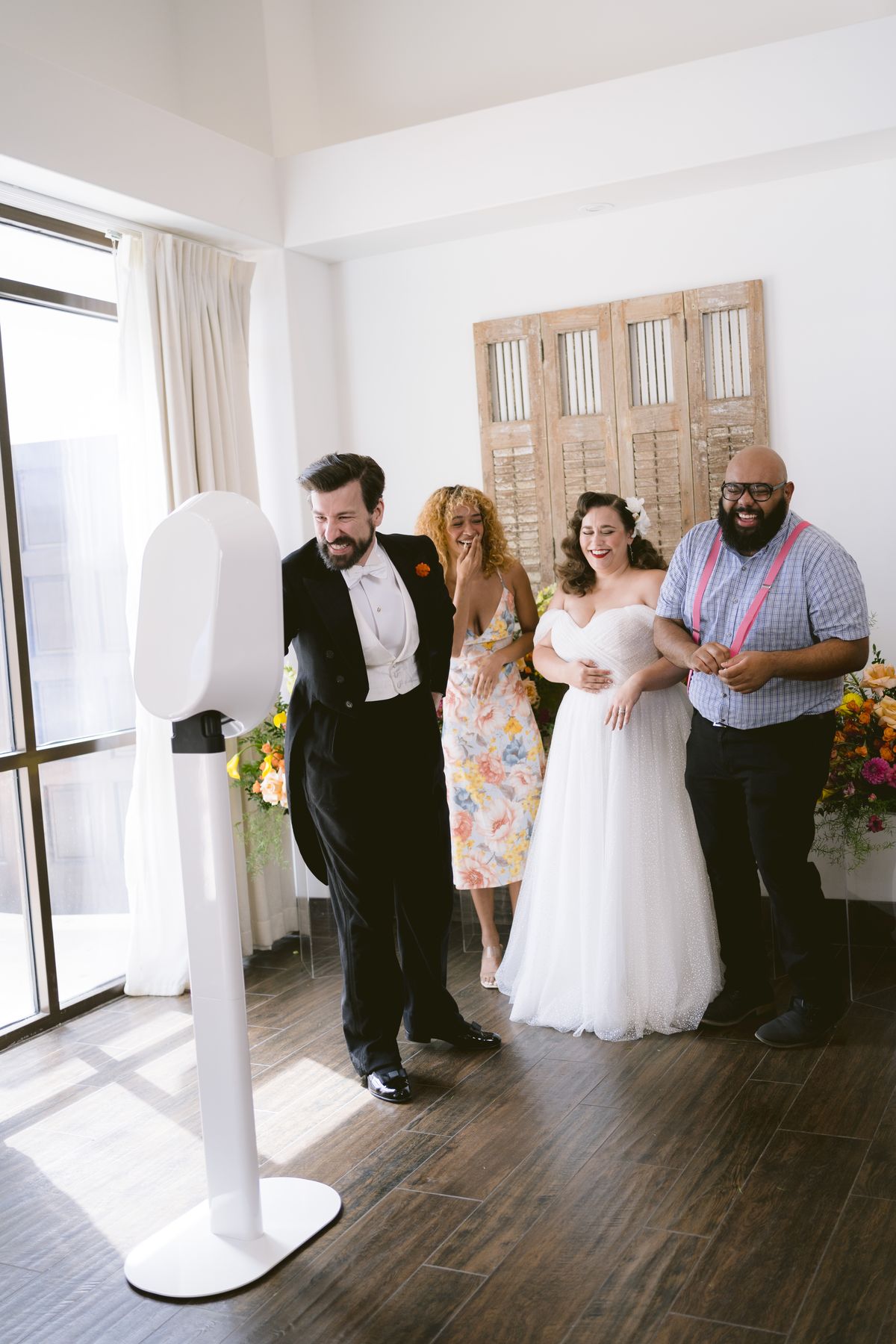 Bride, groom and wedding guests posing together at the photo booth
